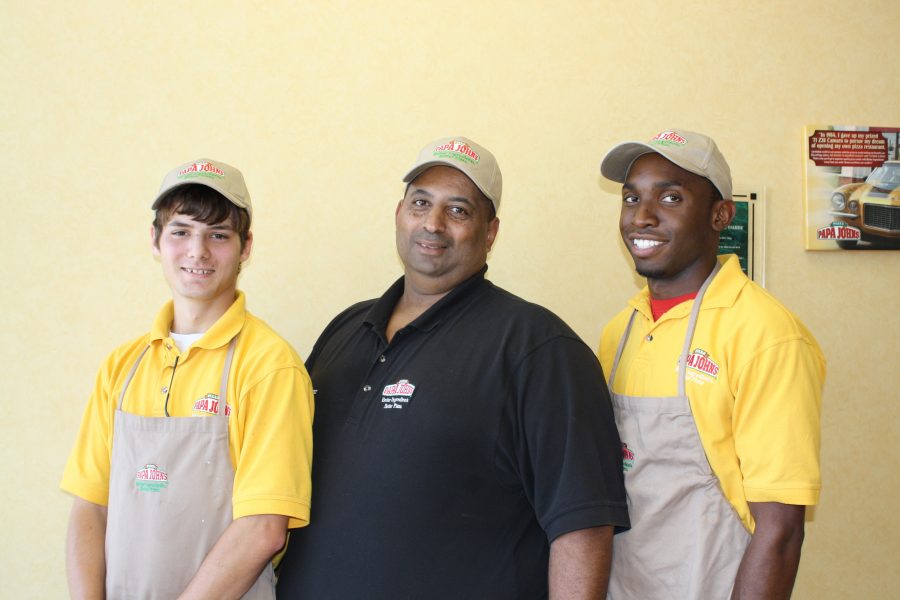 General manager Chris Harmon of Papa John’s works with Dustin McFarlan (left) and sophmore Shawn Alexander (right) at the Louisville Papa John’s.