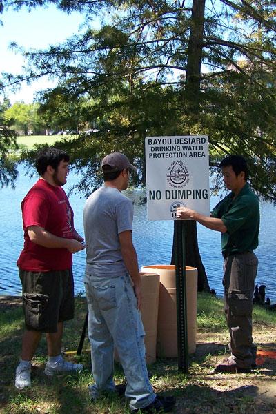 Toxicology students and a professor take water samples in the bayou.