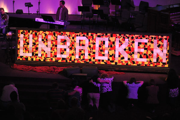 Tiles were written on by church members confessing their deepest personal problems and were used to form the mosaic, forming one word to symbolize how the church can come together. The broken tiles are different colors to represent different races coming together to make one solid piece. People prayed before the mosaic after it was unveiled.