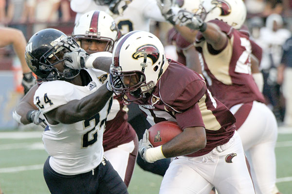 Ambrose stiff-arms a defender in the return for a touchdown against FIU on ULM senior day at Malone Stadium.