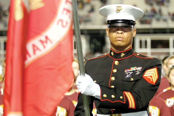 A member of the Marines hold a flag during the National anthem.