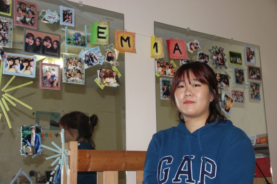 Eunhui Kim hangs pictures in her room of old and new friends.