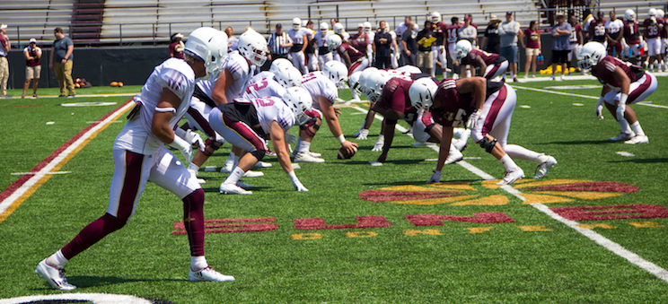 Football players who are normally on the same side line face off against each other in Saturday’s scrimmage at Malone Stadium.  
