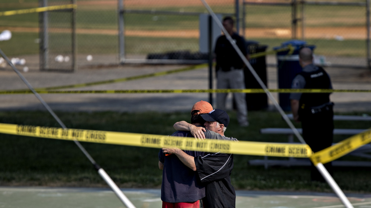 Two people embrace near the blocked-off crime scene in Alexandria, Va., where a congressman and several others were wounded in a shooting during a congressional baseball practice Wednesday. 
