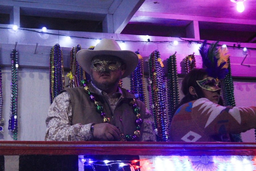 ROLLING ON THE RIVER: A member of the Krewe de Riviere tosses beads to those at the parade.