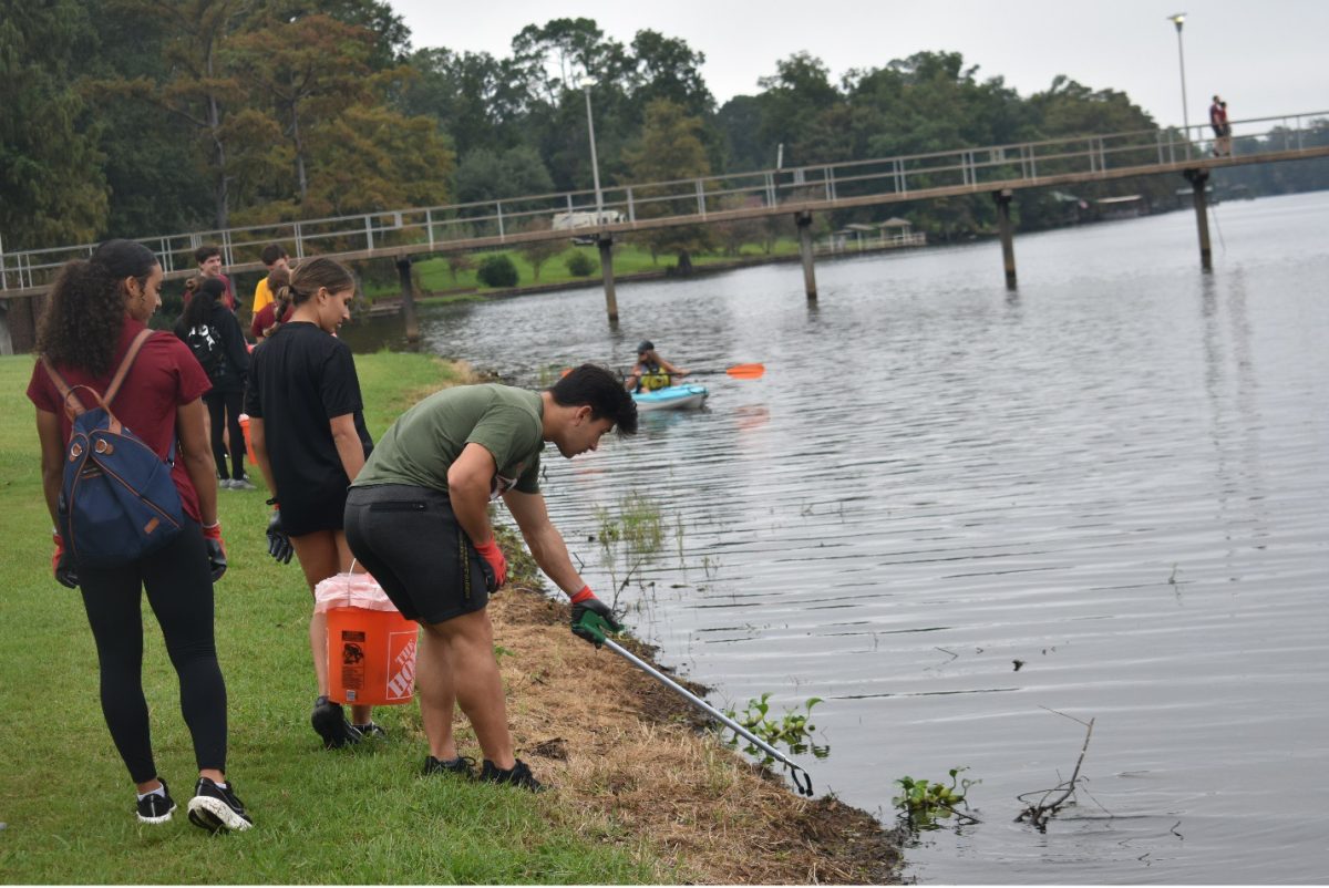 WATCH YOUR STEP: Students pick up trash while struggling to stay dry.