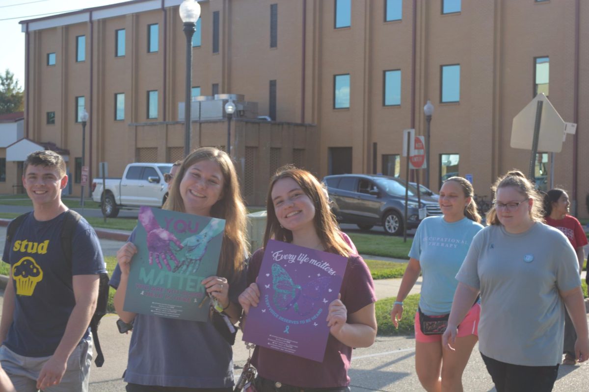 Students walking in the Suicide Prevention Walk are holding signs to show their support.  