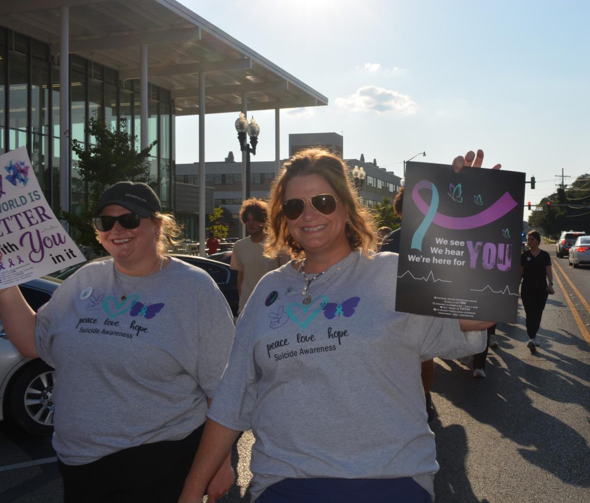 Two women holding signs to support Suicide Prevention month.  