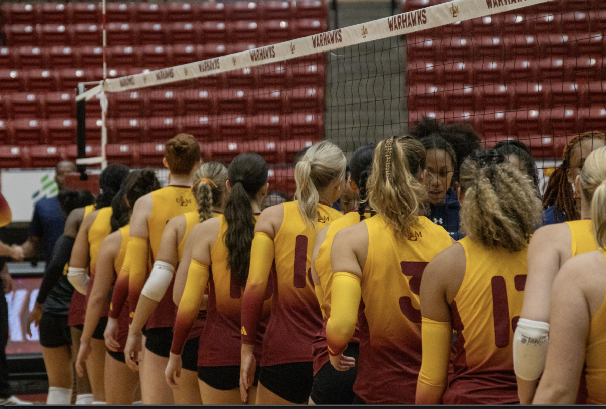 ULM volleyball team’s players shaking hands with opponent after a game .